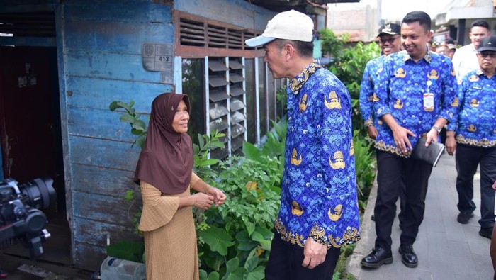 1763463974730-wali-kota-palembang-ratu-dewa-bersama-camat-gandus-cek-rumah-yang-akan-direhab-1763425661409_169