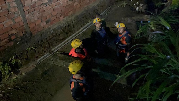 1765602346132-personel-basarnas-saat-menyisir-saluran-air-tempat-bocah-diduga-hanyut-di-jambi-1765550243674_169