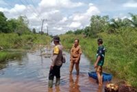 1765991158232-anggota-polsek-indralaya-utara-mengecek-kondisi-banjir-di-jalan-desa-1765946841927_169